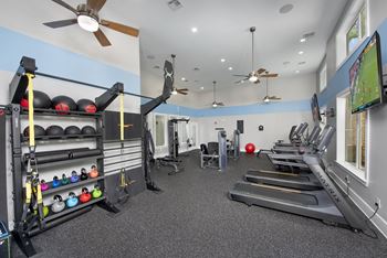 A gym with treadmills, weights, and exercise equipment.